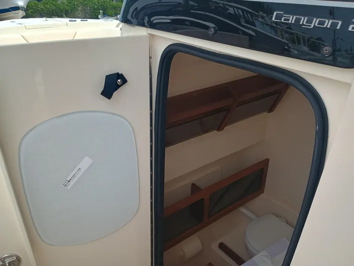  Yacht Photos Pics 2025 Grady-White Canyon 271 boat cabin interior with storage and toilet.