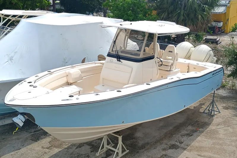  Yacht Photos Pics 2025 Grady-White Canyon 271 boat, light blue hull, parked on stands outdoors.