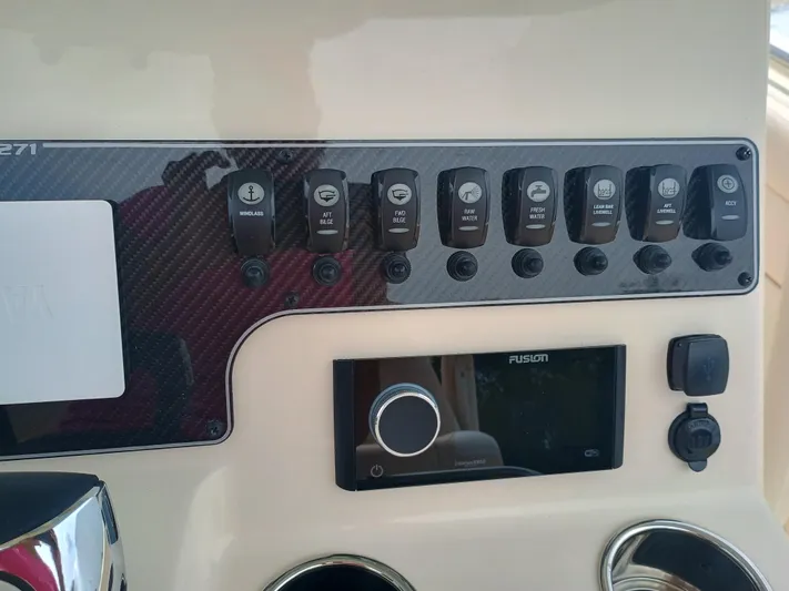  Yacht Photos Pics Control panel of 2025 Grady-White Canyon 271 boat with various switches and a Fusion stereo.