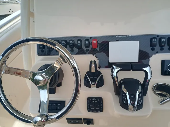  Yacht Photos Pics 2025 Grady-White Canyon 271 boat dashboard with steering wheel and controls.