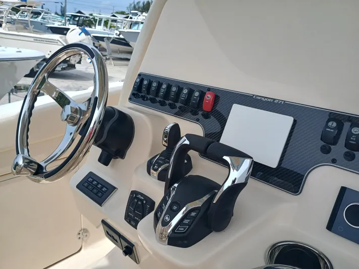  Yacht Photos Pics 2025 Grady-White Canyon 271 boat dashboard with steering wheel and controls.