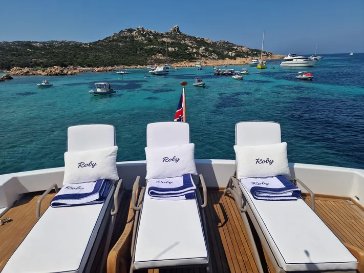 Toi Moi Et Roby Yacht Photos Pics Luxurious Diano 29 yacht deck with sun loungers, overlooking a serene turquoise bay, 2008 model.