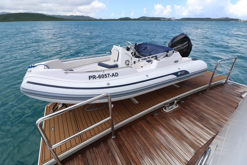  Yacht Photos Pics 2013 Cheoy Lee Bravo yacht with a small boat on deck, docked on calm waters.