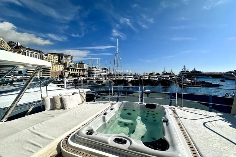 Optimism Yacht Photos Pics Luxurious 2023 Majesty 120 yacht with jacuzzi, docked in a scenic marina.