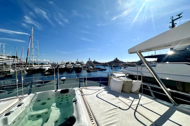 Optimism Yacht Photos Pics Luxurious 2023 Majesty 120 yacht with jacuzzi and sun deck, overlooking marina.
