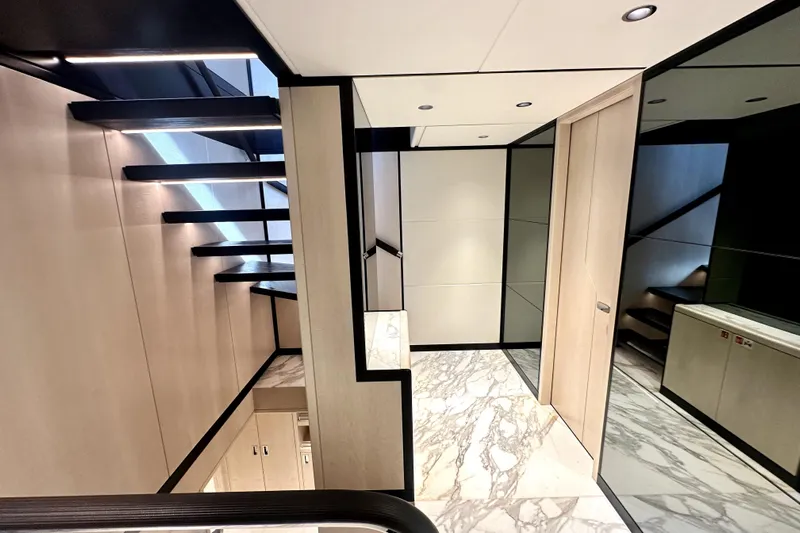 Optimism Yacht Photos Pics Modern interior of 2023 Majesty 120 yacht with sleek staircase and marble flooring.