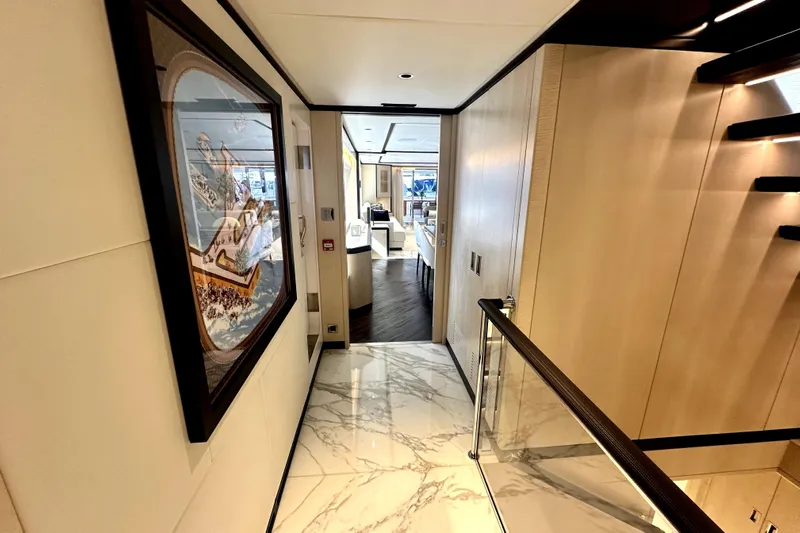 Optimism Yacht Photos Pics Luxurious interior hallway of 2023 Majesty 120 yacht with elegant decor and marble flooring.