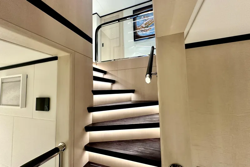 Optimism Yacht Photos Pics Luxurious interior staircase of 2023 Majesty 120 yacht with modern lighting.
