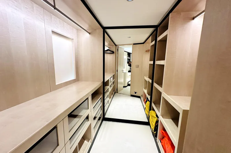 Optimism Yacht Photos Pics Luxurious walk-in closet on 2023 Majesty 120 yacht, featuring ample shelving and modern design.
