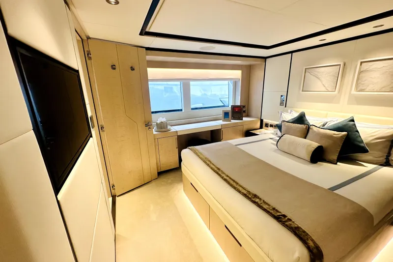 Optimism Yacht Photos Pics Luxurious bedroom interior of 2023 Majesty 120 yacht, featuring elegant decor and modern amenities.