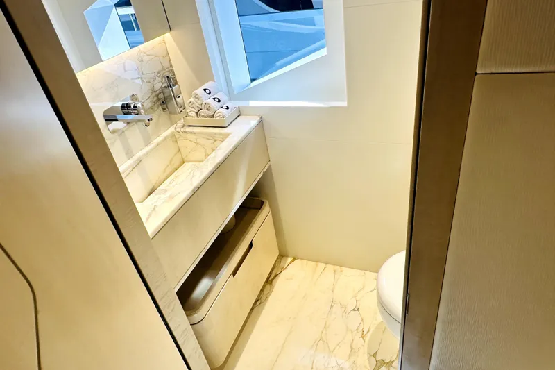 Optimism Yacht Photos Pics Luxurious bathroom in 2023 Majesty 120 yacht with marble sink and modern fixtures.