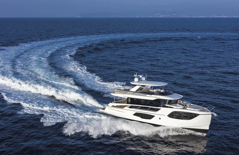 Absolute Navetta 64 Yacht Photos Pics 2025 Absolute Navetta 64 yacht cruising on open sea, creating a dynamic water trail.