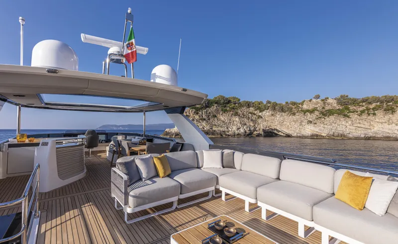 Absolute Navetta 64 Yacht Photos Pics Luxurious 2025 Absolute Navetta 64 yacht with spacious deck and elegant seating, near scenic coastline.