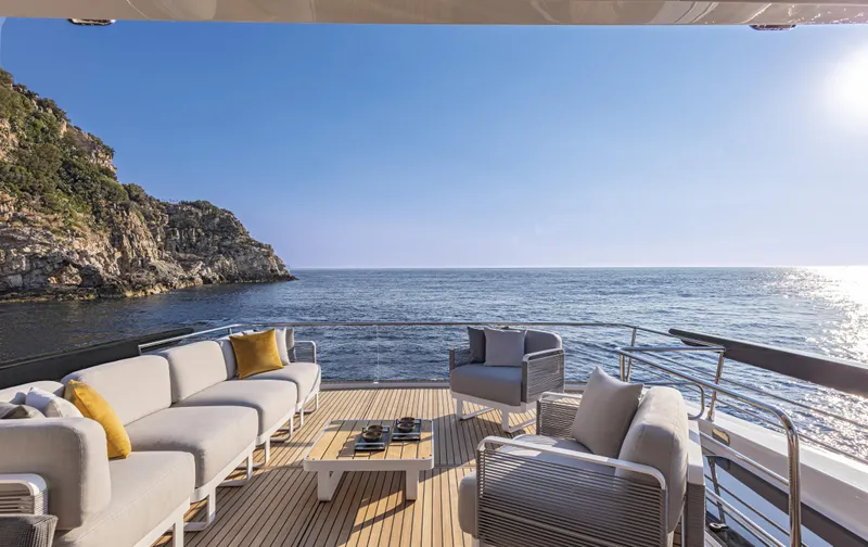 Absolute Navetta 64 Yacht Photos Pics Luxurious 2025 Absolute Navetta 64 yacht deck with elegant seating, ocean view, and sunny sky.