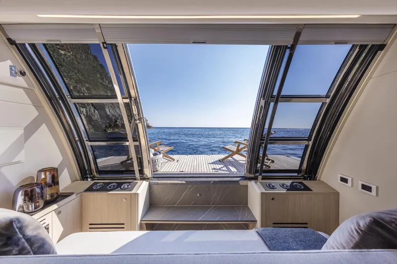Absolute Navetta 64 Yacht Photos Pics Luxurious interior of 2025 Absolute Navetta 64 yacht with ocean view and deck chairs.