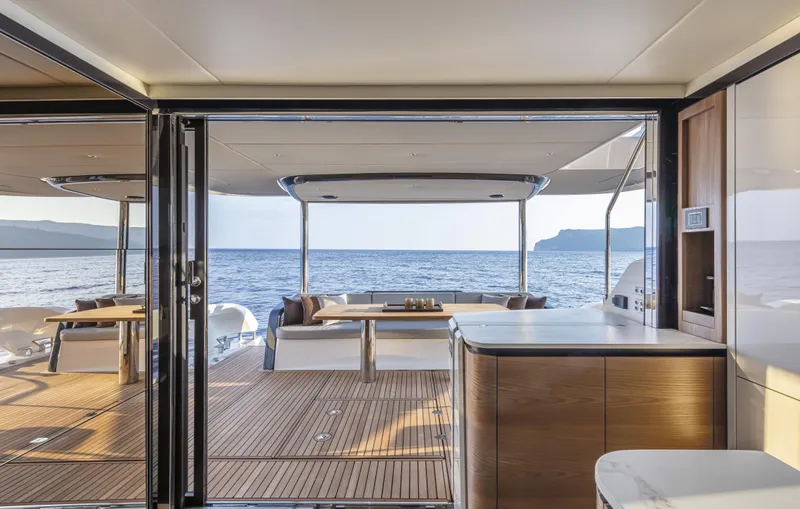 Absolute Navetta 64 Yacht Photos Pics Luxurious interior of 2025 Absolute Navetta 64 yacht with ocean view and elegant wood finishes.
