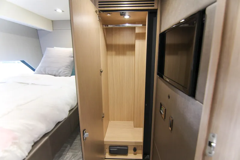  Yacht Photos Pics Interior of 2017 Sunseeker Predator 57 yacht, featuring a wooden wardrobe and cozy bedroom.