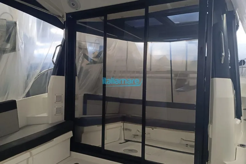  Yacht Photos Pics 2019 Jeanneau Merry Fisher 895 interior with sliding glass doors and seating area.