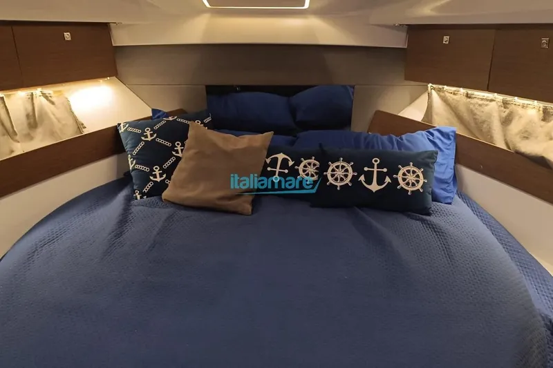  Yacht Photos Pics Cozy cabin interior of 2019 Jeanneau Merry Fisher 895 with nautical-themed pillows.