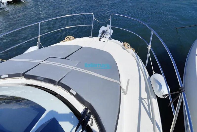  Yacht Photos Pics 2019 Jeanneau Merry Fisher 895 boat deck with sunpad, docked on calm water.