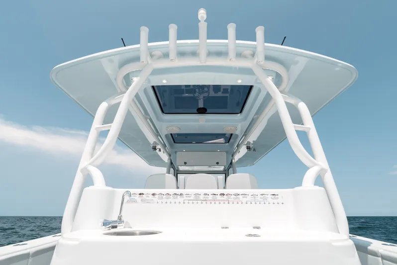  Yacht Photos Pics 2017 Yellowfin 42 boat console with rod holders against a clear blue sky.