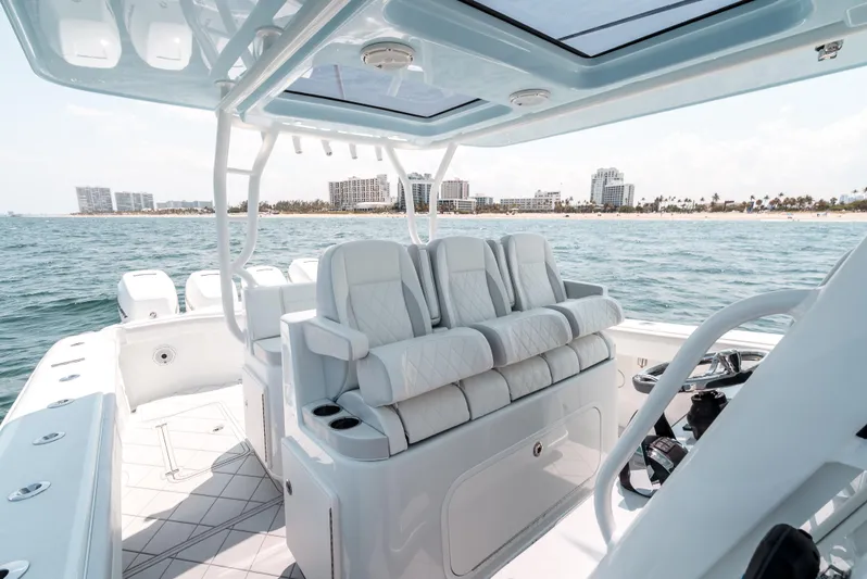  Yacht Photos Pics 2017 Yellowfin 42 boat interior with plush seating, ocean view, and city skyline in the background.