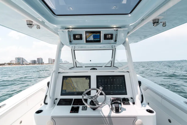 Yacht Photos Pics 2017 Yellowfin 42 boat dashboard with navigation screens and steering wheel on open water.