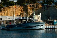 2024 Solaris Power 60 Open yacht docked at a marina with rocky backdrop.