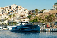 2024 Solaris Power 60 Open yacht docked in a scenic marina with coastal buildings.