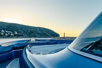 2024 Solaris Power 60 Open yacht cruising near coastal landscape at sunset.