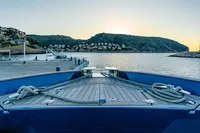 2024 Solaris Power 60 Open yacht docked at scenic harbor during sunset.