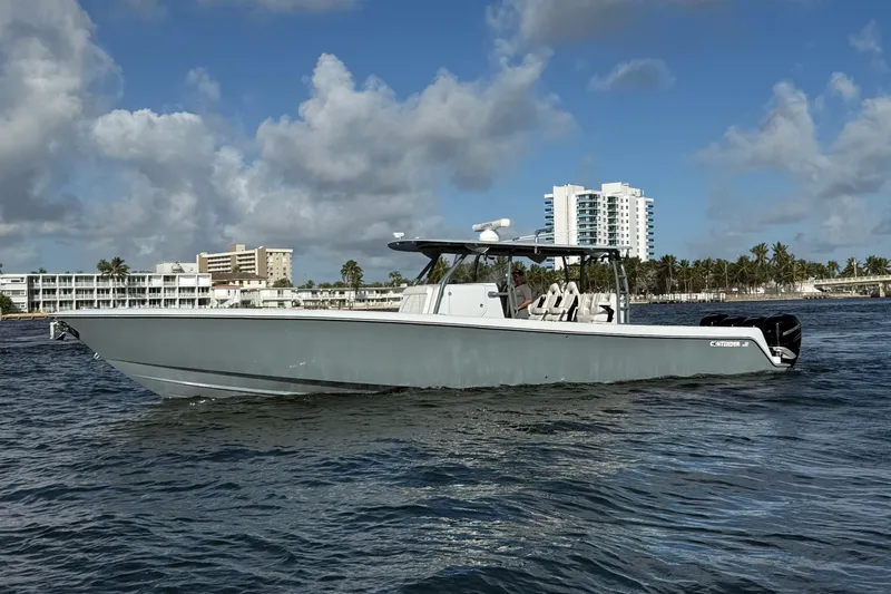  Yacht Photos Pics 2023 Contender 44 CB boat cruising on water near coastal buildings.