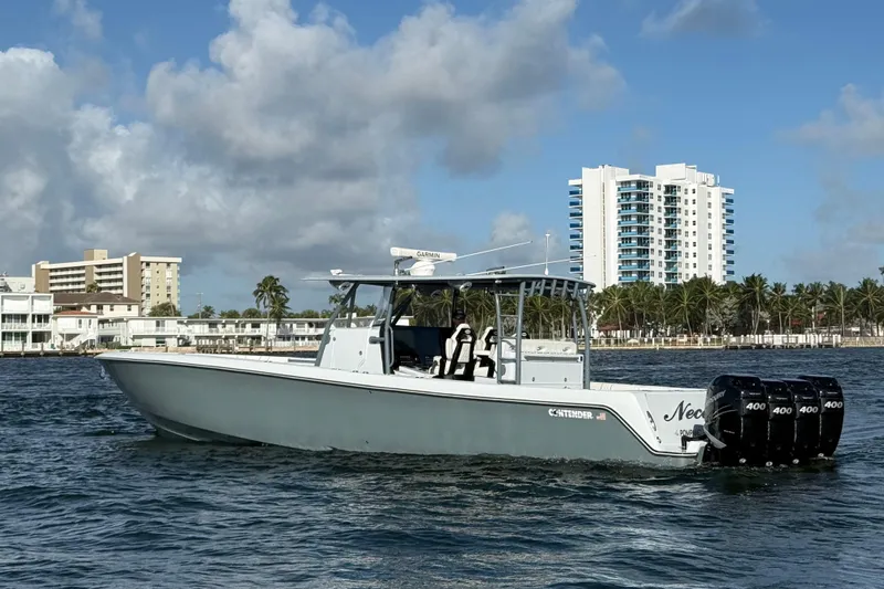  Yacht Photos Pics 2023 Contender 44 CB boat cruising near coastal buildings and palm trees.