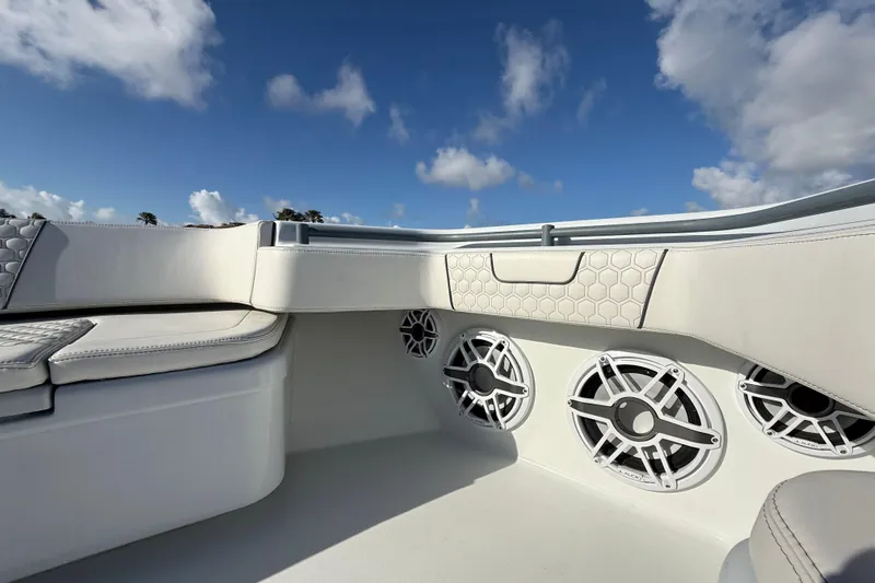  Yacht Photos Pics 2023 Contender 44 CB boat interior with speakers and cushioned seating under blue sky.