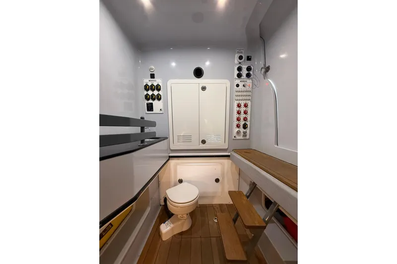  Yacht Photos Pics Interior of 2023 Contender 44 CB boat featuring a compact bathroom with control panels.