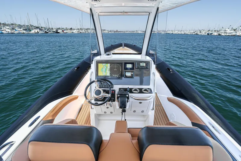Jilly Bean Yacht Photos Pics 2025 Airship 340 boat cockpit with navigation system, steering wheel, and luxurious seating on open water.