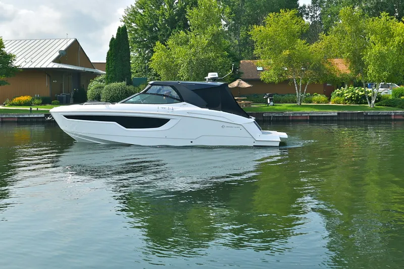  Yacht Photos Pics 2026 Cruisers Yachts 38 GLS I/O on a serene lake with lush greenery.