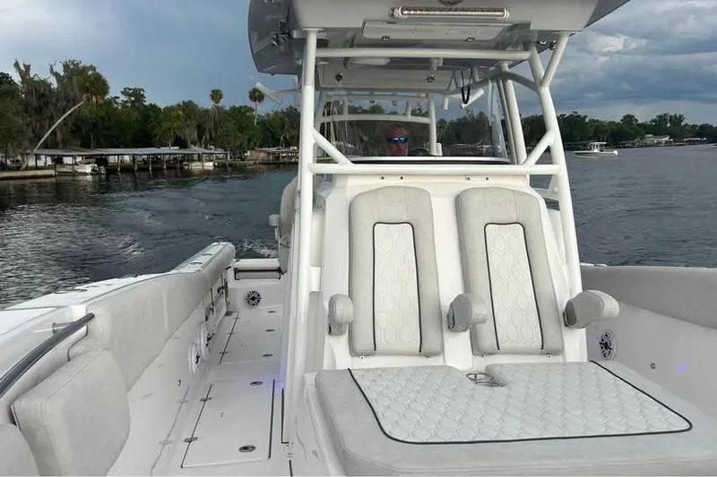 Yacht Photos Pics 2023 Sea Fox 328 Commander boat on a calm lake with lush shoreline.