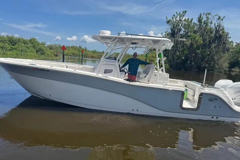  Yacht Photos Pics 2023 Sea Fox 328 Commander boat on calm water, surrounded by lush greenery.