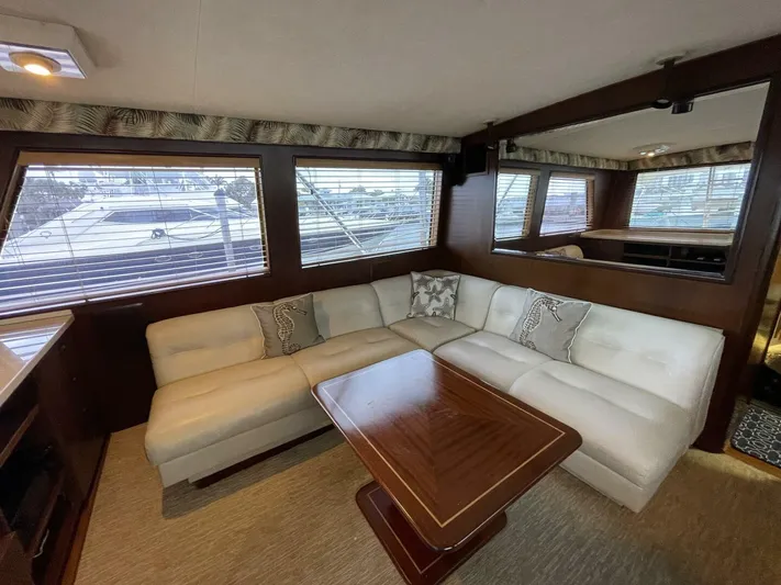 Moonshine Yacht Photos Pics Luxurious 1985 Hatteras Enclosed Bridge yacht interior with plush seating and elegant wood table.