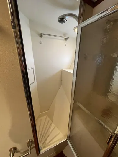 Moonshine Yacht Photos Pics 1985 Hatteras Enclosed Bridge yacht shower with glass door and modern fixtures.