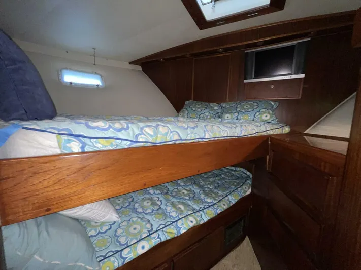 Moonshine Yacht Photos Pics Interior of 1985 Hatteras Enclosed Bridge with bunk beds and floral bedding.