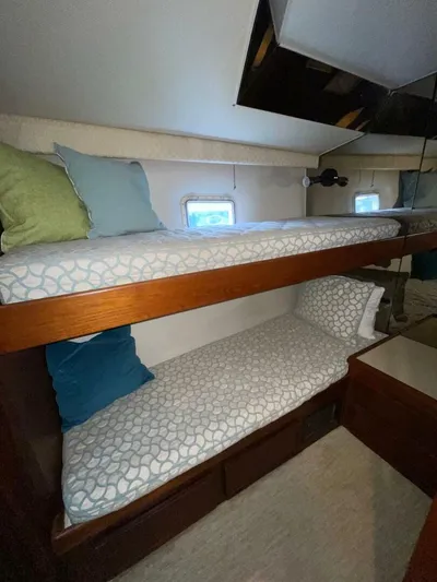 Moonshine Yacht Photos Pics 1985 Hatteras Enclosed Bridge cabin with bunk beds, cozy bedding, and small windows.