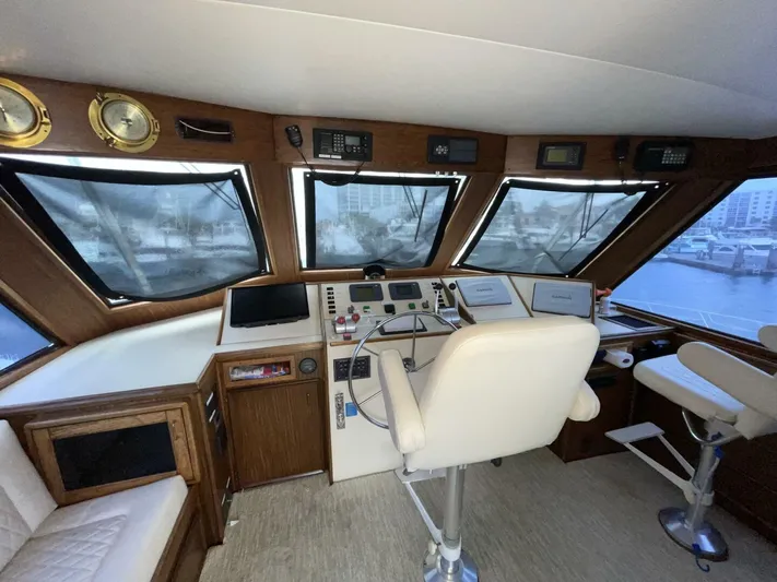 Moonshine Yacht Photos Pics 1985 Hatteras Enclosed Bridge helm with navigation equipment and panoramic windows.