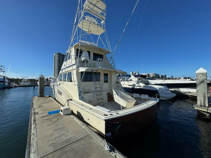 Moonshine Yacht Photos Pics 1985 Hatteras Enclosed Bridge yacht docked at a marina under clear blue skies.