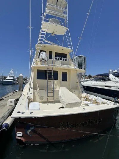 Moonshine Yacht Photos Pics 1985 Hatteras Enclosed Bridge yacht docked at marina under clear blue sky.
