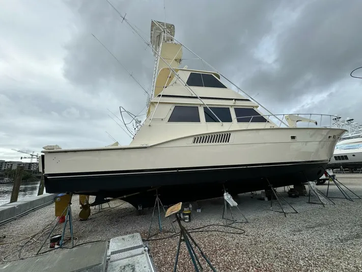 Moonshine Yacht Photos Pics 1985 Hatteras Enclosed Bridge yacht on dry dock under cloudy skies.