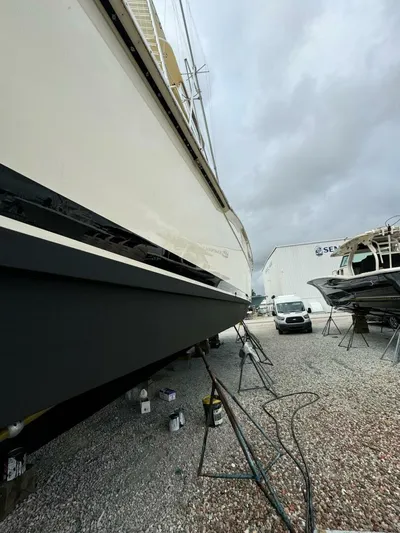 Moonshine Yacht Photos Pics 1985 Hatteras Enclosed Bridge yacht in dry dock, side view with overcast sky.