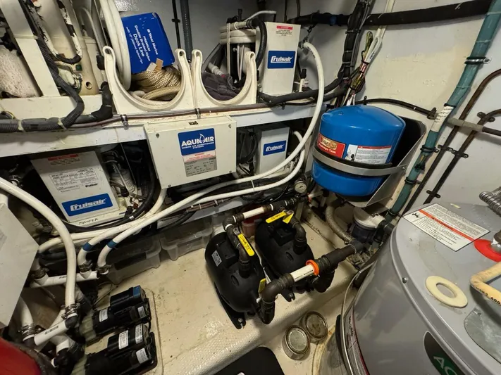 Moonshine Yacht Photos Pics Engine room of 1985 Hatteras Enclosed Bridge with AquaAir systems and various equipment.