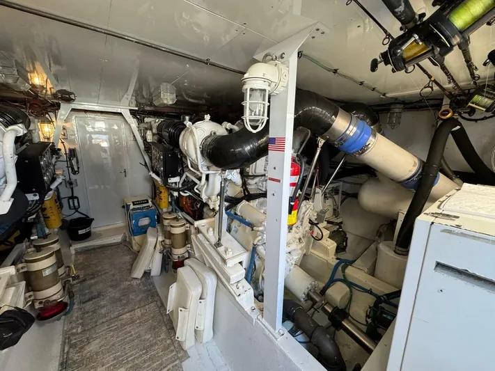 Moonshine Yacht Photos Pics Engine room of a 1985 Hatteras Enclosed Bridge yacht, showcasing machinery and equipment.